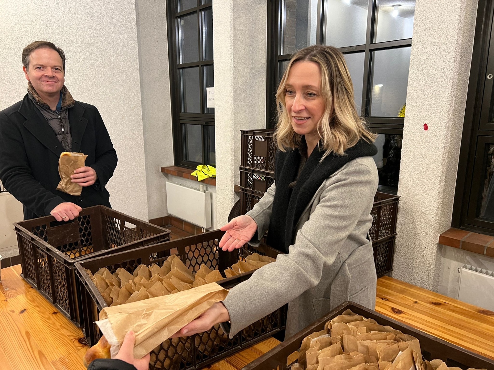 Schulleiterin Schlösser verteilt mit Erprobungsstufenkoordinator Segger-Schützeichel die von der Bulle Bäckerei gespendeten Weckmänner